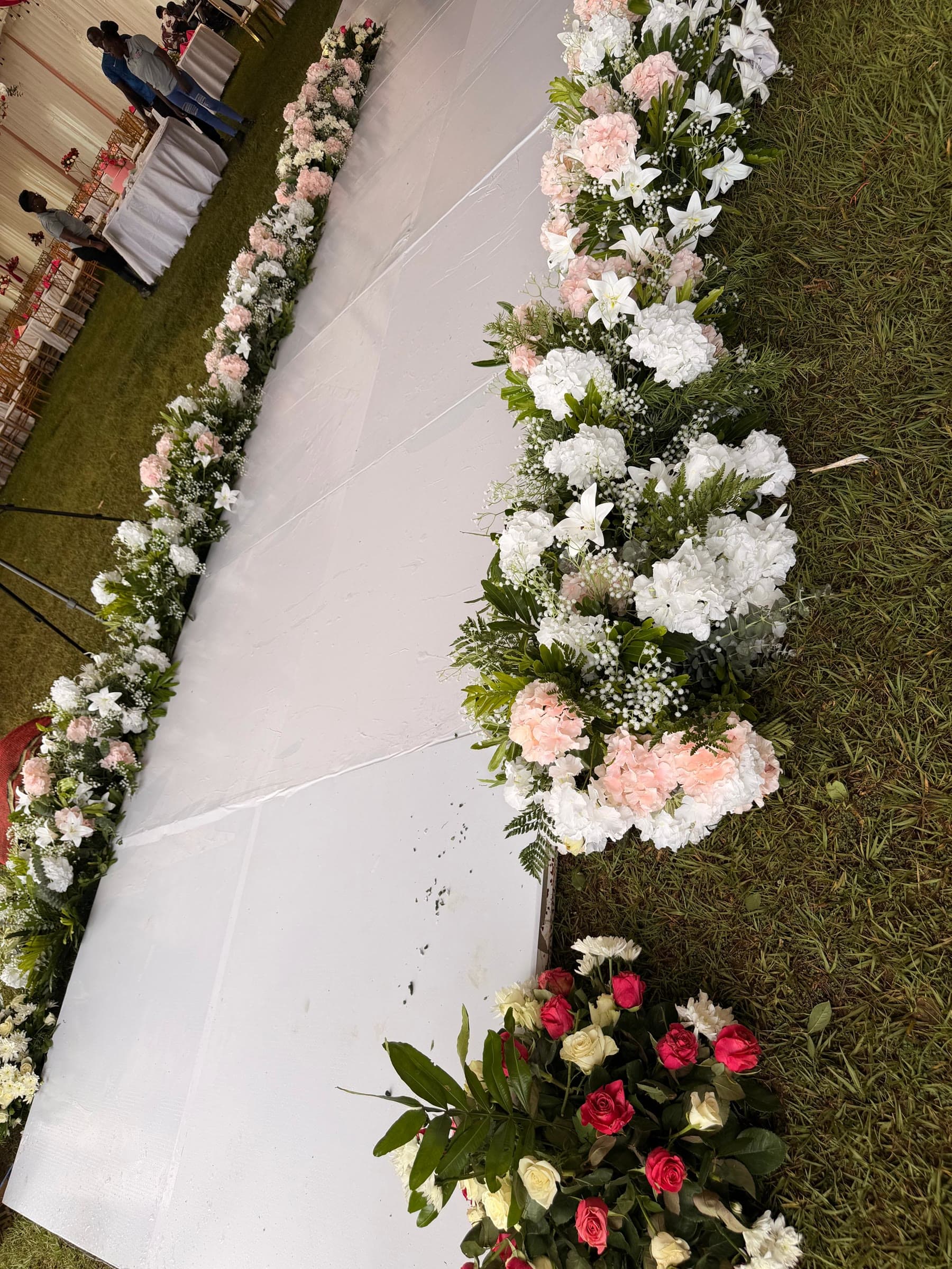 A crystal chandelier hung among coral and cream drapes gathered into the peak of the marquee roof