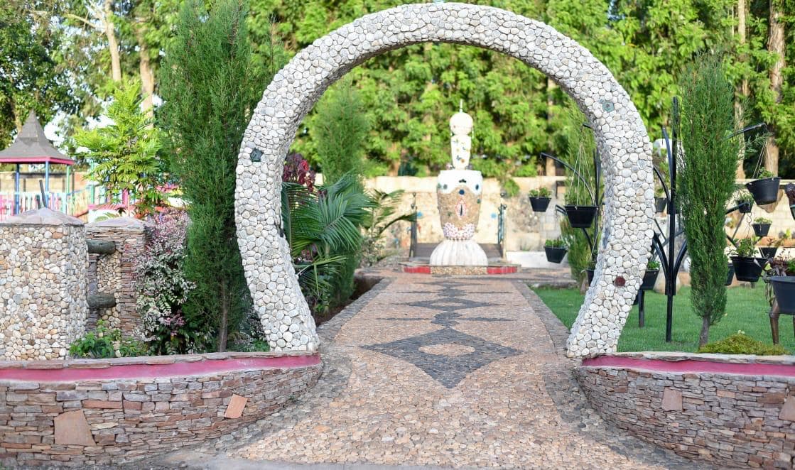 A pebble-mosaic path leading through a stone-studded arch